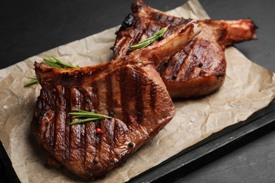 Delicious beef steaks with rosemary on black table, closeup