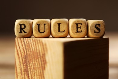 Word Rules made of cubes with letters on wooden block, closeup