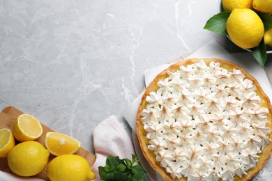Flat lay composition with delicious lemon meringue pie on light grey table, space for text