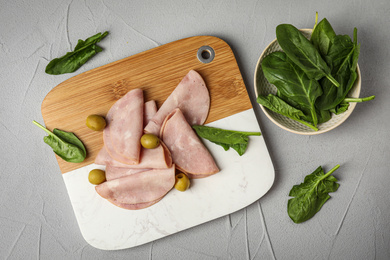 Ham with olives and spinach on light grey table, flat lay