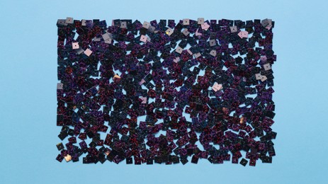 Beautiful sequins on light blue background, flat lay