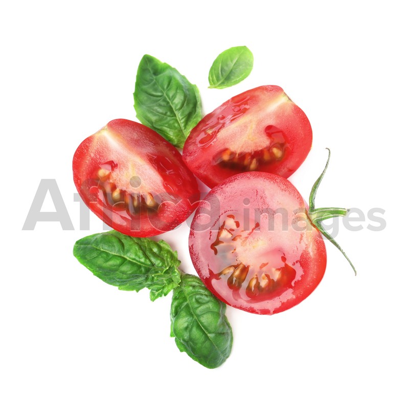 Photo of Fresh green basil leaves with cut tomato on white background, top view