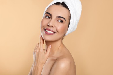 Photo of Young woman with towel on beige background. Spa treatment