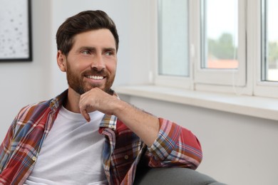 Smiling bearded man looking away at home