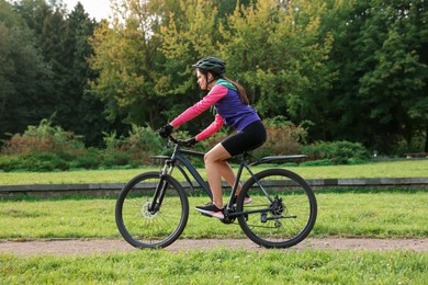 Photo of Young woman riding bicycle on road outdoors