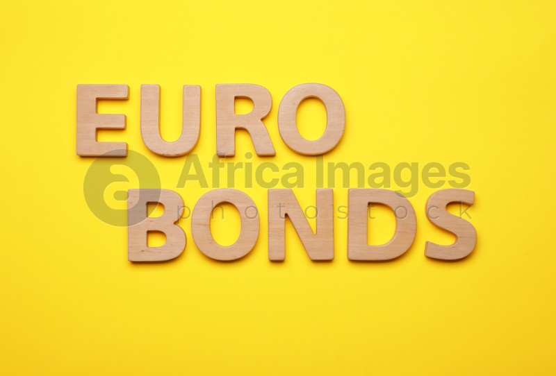 Word Eurobonds made of wooden letters on yellow background, flat lay