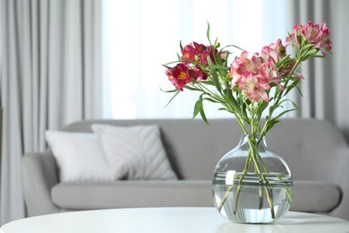 Photo of Vase with beautiful alstroemeria flowers on table in living room, space for text. Stylish element of interior design