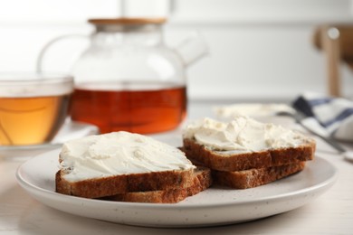 Photo of Bread with cream cheese on white wooden table