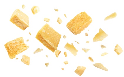 Pieces of delicious parmesan cheese flying on white background
