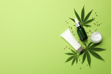 Flat lay composition with CBD oil or THC tincture and hemp leaves on green background, space for text