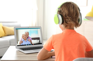 Little boy talking with his grandparents via videocall application at home