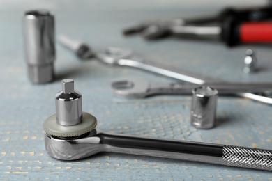 Photo of Auto mechanic's tool on grey wooden table, closeup