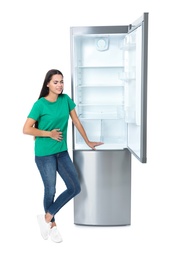 Hungry woman near empty refrigerator on white background