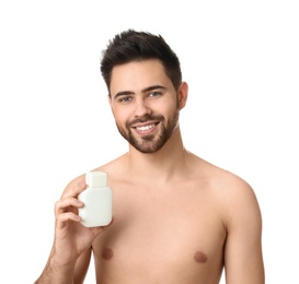 Handsome young man with beard holding post shave lotion on white background