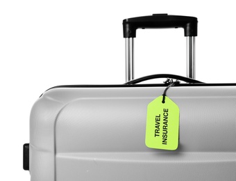 Grey suitcase with TRAVEL INSURANCE label on white background, closeup