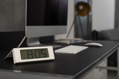 Electronic clock near computer on table indoors, space for text. Interior element