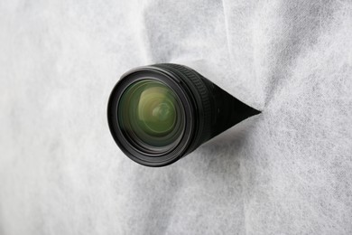 Hidden camera lens through torn hole in white fabric