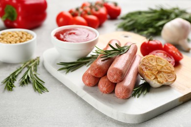 Delicious vegetarian sausages with rosemary and vegetables on grey table