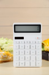 Calculator and food products on wooden table. Weight loss concept