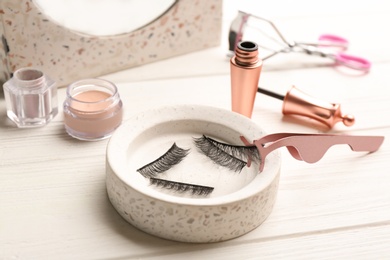 Photo of Magnetic eyelashes and accessories on white wooden table