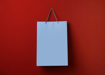 Paper shopping bag hanging on red background