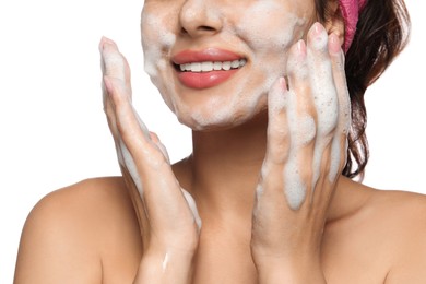 Beautiful woman applying facial cleansing foam on white background, closeup