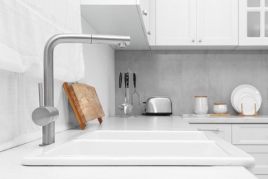Photo of Modern sink and water tap in kitchen. Interior design