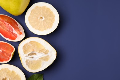 Photo of Different sorts of tasty pomelo fruits on dark blue background, flat lay. Space for text