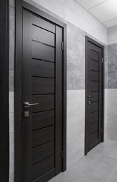 Public toilet interior with stylish doors and tiles