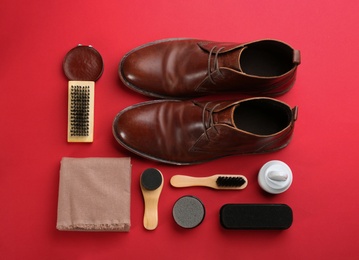 Flat lay composition with shoe care accessories and footwear on red background