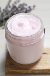 Jar of hand cream on white wooden table, closeup