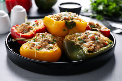 Tasty stuffed bell peppers served on grey table