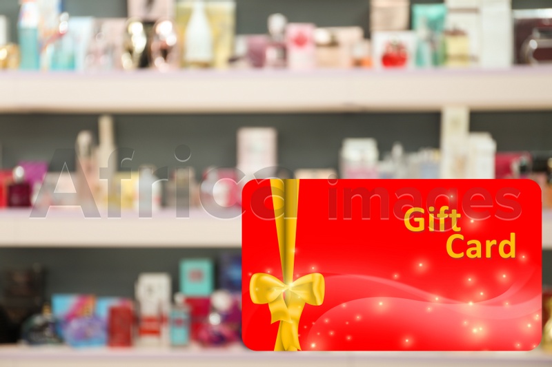 Image of Store gift card. Blurred view of shelves with perfume bottles in shop