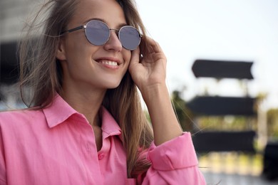 Beautiful young woman in stylish sunglasses outdoors, closeup