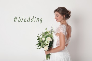 Young bride with beautiful bouquet and hashtag Wedding on white background 