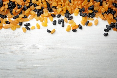 Raisins on wooden background, top view with space for text. Dried fruit as healthy snack