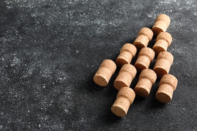 Photo of Christmas tree made of sparkling wine corks on grey table. Space for text