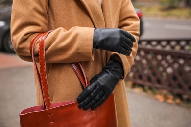 Young woman in black leather gloves, closeup. Stylish clothes