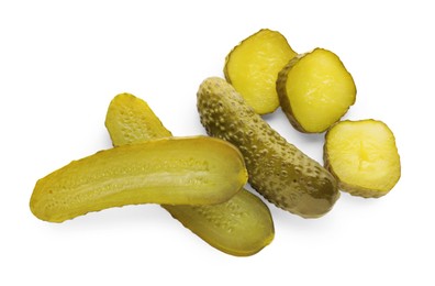 Tasty sliced and whole pickled cucumbers on white background, top view