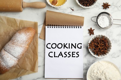 Image of Notebook with inscription Cooking Classes, cooking utensils and ingredients on white marble table, flat lay