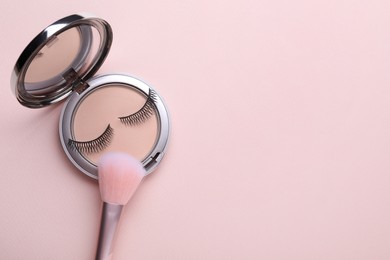 Photo of False eyelashes and face powder with brush on pink background, flat lay. Space for text