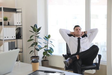 Photo of Businessman relaxing in office chair at workplace