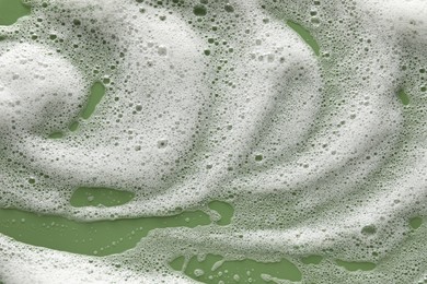 White washing foam on olive background, top view