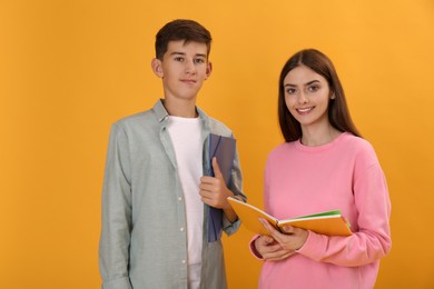 Teenage students with stationery on yellow background