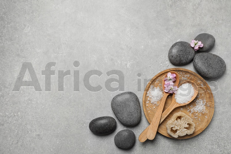 Flat lay composition with sea salt and spa stones on grey marble table. Space for text
