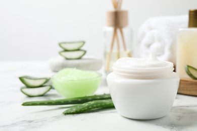 Open jar of cream and aloe on white marble table. Organic cosmetics