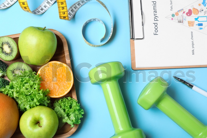 Fruits, dumbbells, measuring tape and list of products on light blue background, flat lay. Visiting nutritionist