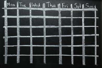 Weekly school timetable drawn on black chalkboard