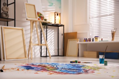 Abstract picture and wooden easel in art studio