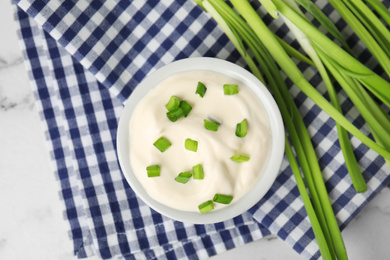 Fresh sour cream with onion on fabric, flat lay